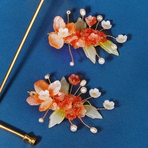 Detail of handmade Chinese resin flower hairpins with pearls and green leaves for brides