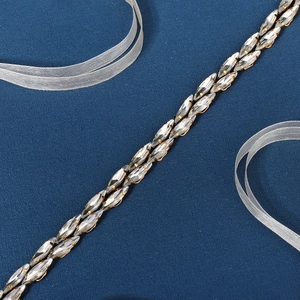 Detail of double-row marquise cut rhinestones on a gold bridal belt with blue background