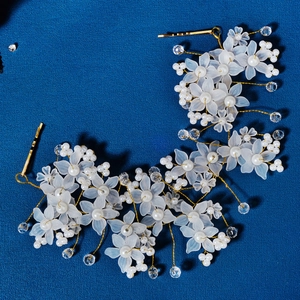 Close-up of handmade bridal headband with frosted white flowers, pearls and crystals