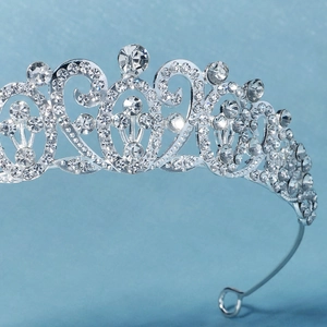 Macro side view of baroque silver crown with intricate filigree and crystal detailing