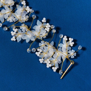 Detail view of bridal hair accessory with white acrylic flowers and crystal beads