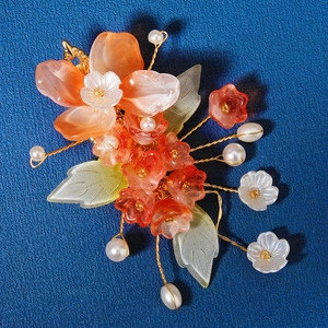 Close-up of handmade resin flowers and pearls with golden wire for bridal hair clips
