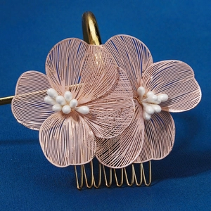Détail du peigne à cheveux fleurs en fil rose avec perles blanches et base dorée chic