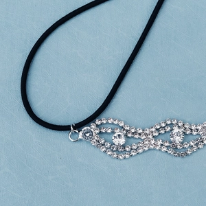 Macro detail of wave-shaped rhinestone headband with crystal centerpieces and elastic band