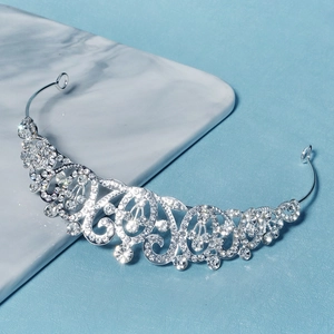 Detailed macro shot of silver baroque crown with shimmering rhinestones on marble