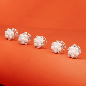 Barrettes à cheveux fleurs en perles et strass pour chignons de mariée sur fond orange