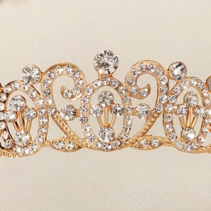 Close-up of golden baroque crown with intricate filigree and shimmering clear rhinestones