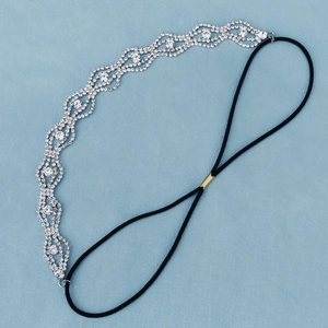 Detailed close-up of wavy crystal headband with silver rhinestones and elastic band