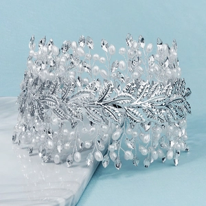 Squisita corona da sposa con foglie d'argento e perle bianche su fondo in marmo