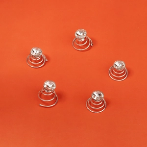 Fünf silberne Spiral-Haarklammern mit großen funkelnden Strasssteinen auf orangefarbenem Grund