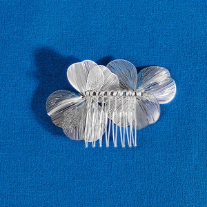 Détail d'un peigne à cheveux de mariée en fleurs d'argent avec pétales en métal tissé