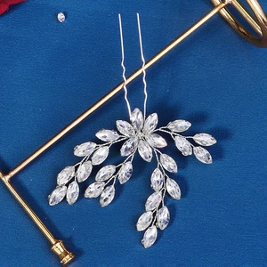 Detail of silver U-shaped bridal hair pin with marquise crystals on dark background