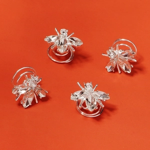 Détail de quatre spirales à cheveux argentées en forme d'abeille avec strass brillants