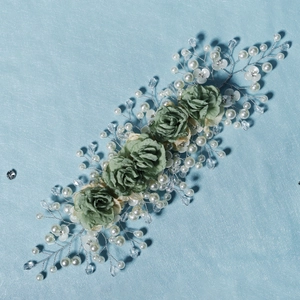 Detail of handmade green fabric roses with woven pearls and crystals on silver wire