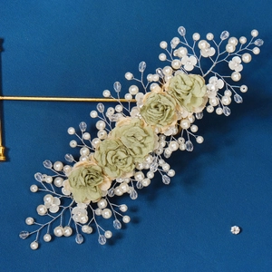 Vintage floral bridal headband with light green fabric roses and pearls on blue backdrop