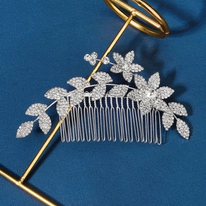 Gros plan d'un peigne à cheveux argenté avec fleurs et strass sur fond bleu foncé