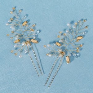 Detail of handmade gold hair pins featuring pearls, crystals, and amber beads set