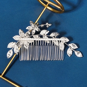 Vue détaillée du peigne à cheveux fleur argentée avec strass sur tissu bleu foncé