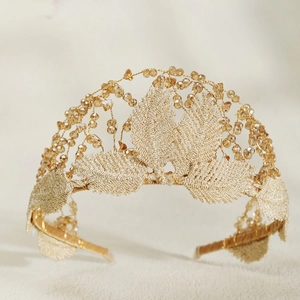 Detailed macro view of golden embroidered leaf headpiece with champagne crystal beads