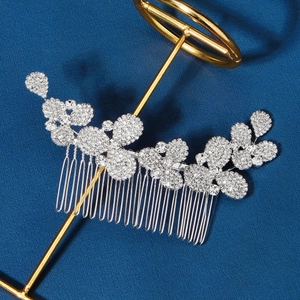 Détail d'un peigne à cheveux argenté pour mariée avec strass sur fond bleu foncé
