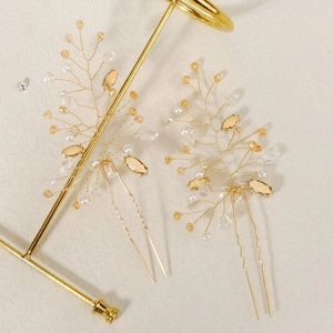 Detail of two handmade gold wire hair pins with pearls and crystals for elegant bridal updos