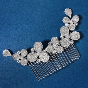 Gros plan du peigne à cheveux floral argenté avec strass brillants sur fond bleu texturé