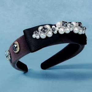 Detail of velvet headband with black satin bow, faux pearls and sparkling rhinestones
