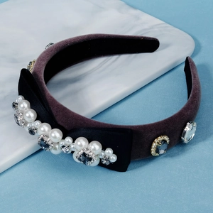 Detail of velvet headband with faux pearls, rhinestones and black silk bow decor