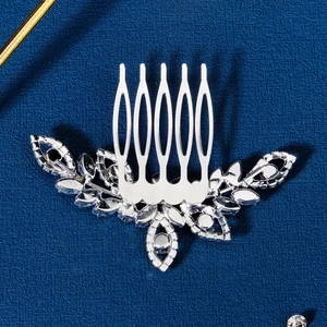 Macro detail of bridal silver flower hair comb with zircon crystals on blue background