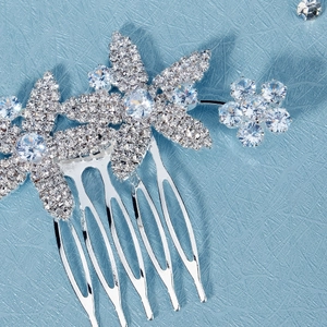 Macro detail of bridal hair comb featuring zircon flowers and silver alloy teeth