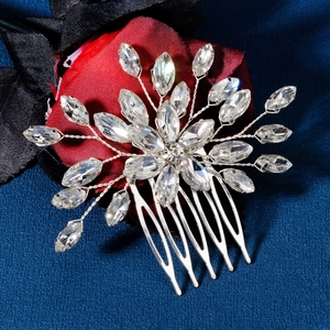 Elegant silver bridal hair comb with marquise crystals on a red silk background