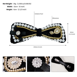 Macro detail of black velvet bow hair clip with imitation pearls and rhinestone cluster