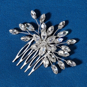 Exquisite silver bridal hair comb with marquise rhinestones on textured blue background
