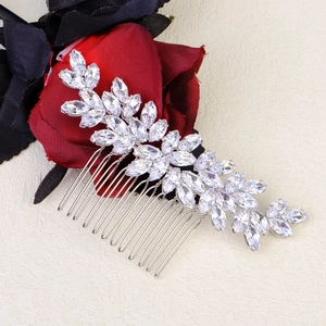 Detailed close-up of sparkling marquise-cut crystal leaves on a bridal silver hair comb