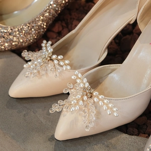 Close-up of elegant crystal and pearl floral shoe clip on pointed-toe wedding heels