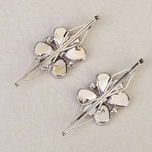 Detailansicht silberner Blumen-Haarspangen mit lila Strasssteinen und Metallstruktur