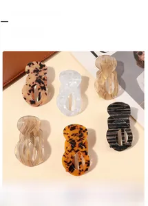 Set of six hair claw clips in tortoiseshell and marble patterns shown in overhead view