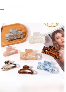Flat lay of square and oval hair claw clips with tortoiseshell and marble patterns