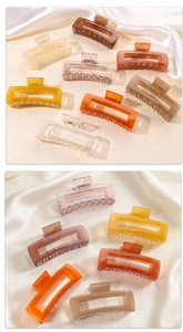 Dettaglio di grandi mollettoni per capelli opachi traslucidi in vari colori eleganti
