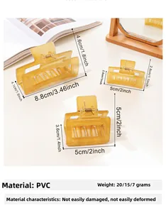 Three sizes of amber square hair claws on a warm cream desk with dimension markings