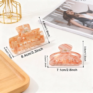 Elegant tortoiseshell claw clips with pink marble texture on a stylish magazine