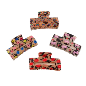 Four leopard print hair claws set with rainbow, flower, lips, and strawberry bow designs