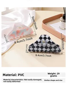 Close-up of marble texture and checkerboard hair claw clips on a wooden tray with satin