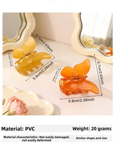 Detailed view of amber and orange butterfly hair claws with precise dimensions and PVC texture