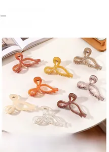 Close-up of translucent bow-shaped hair claws in eight different colors on a desk