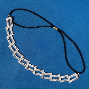 Détail de cadres carrés argentés avec strass et sangle élastique noire sur le bandeau de tête