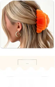 Detail of a bright orange croissant hair claw clip with a glossy translucent finish
