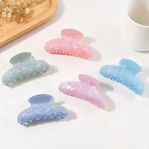 Five pearlescent macaron-colored hair claws in marble texture displayed on white background