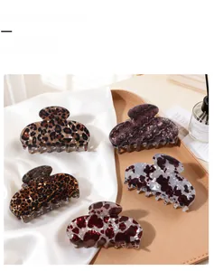 Set of five elegant leopard and marble acetate hair claws displayed on white satin cloth