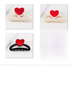 Dettaglio dei fermacelli a cuore in nero e bianco crema con accenti di cuore rosso